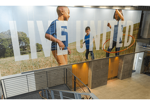 United Way sign with kids running featured in Dallas lobby.