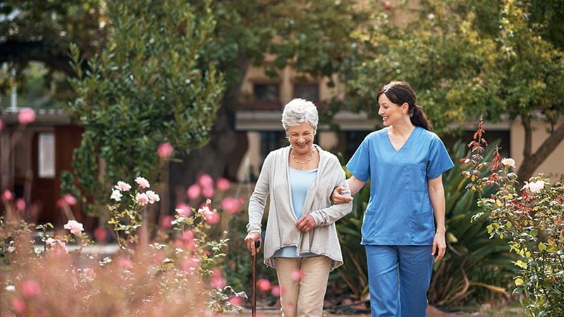 Healthcare worker and woman walking